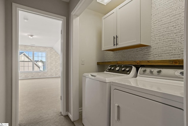 clothes washing area featuring cabinets, carpet flooring, and washing machine and clothes dryer