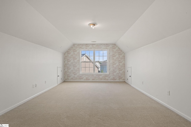 additional living space with light colored carpet and lofted ceiling