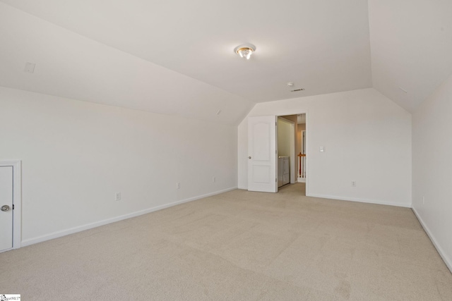 bonus room featuring vaulted ceiling and light colored carpet