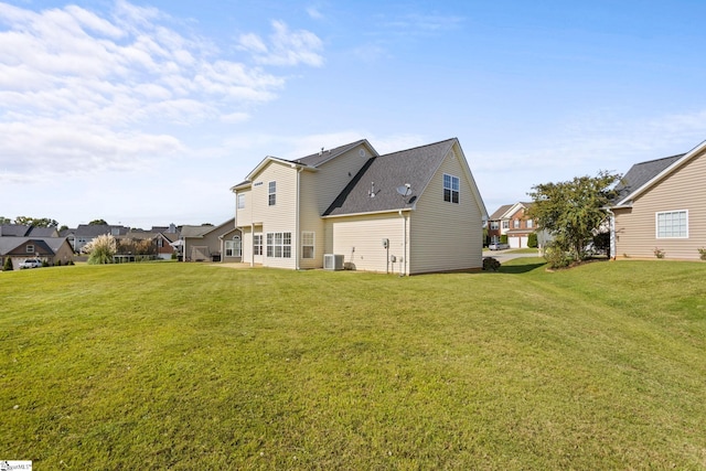 back of property featuring central AC unit and a yard