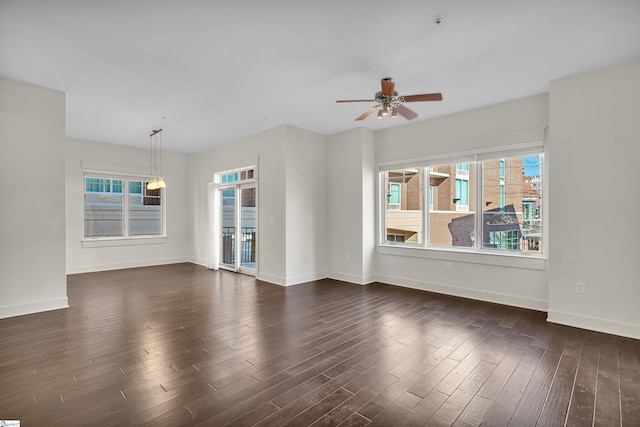 spare room with ceiling fan, plenty of natural light, and dark hardwood / wood-style floors