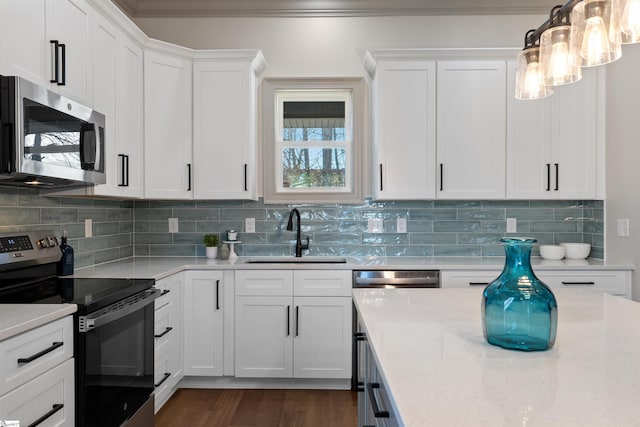 kitchen with tasteful backsplash, sink, hanging light fixtures, appliances with stainless steel finishes, and white cabinets