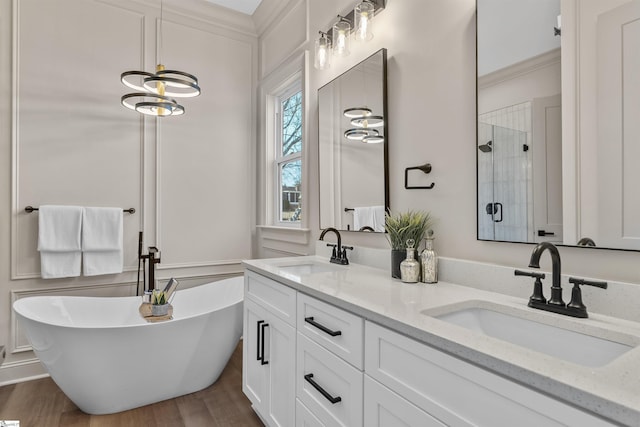 bathroom featuring hardwood / wood-style flooring, vanity, and separate shower and tub