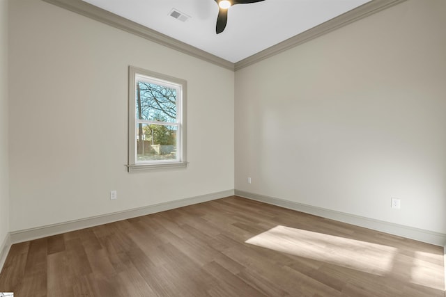 empty room with ceiling fan, ornamental molding, and wood-type flooring