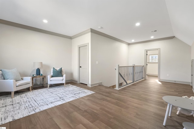 sitting room with hardwood / wood-style flooring, crown molding, and lofted ceiling