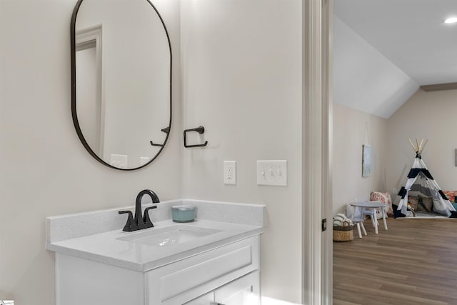 bathroom with vaulted ceiling, wood-type flooring, and vanity