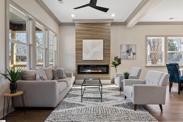 living room featuring ceiling fan, a large fireplace, crown molding, and hardwood / wood-style floors