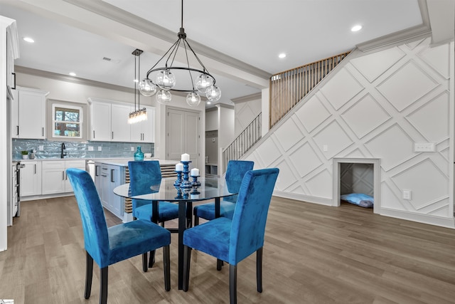 dining room featuring beam ceiling, wood-type flooring, sink, and crown molding