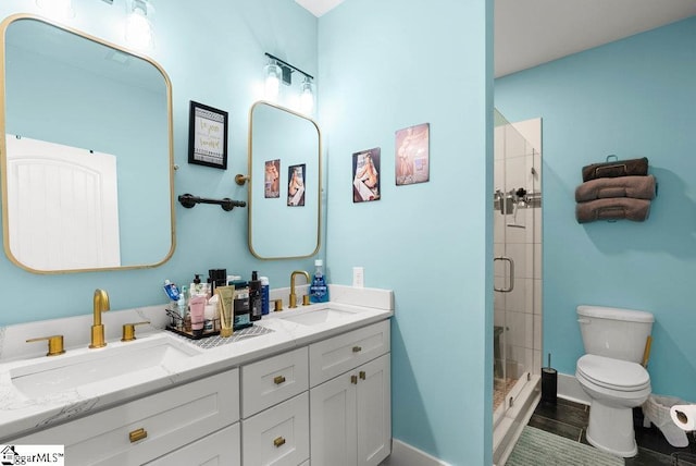 bathroom with toilet, vanity, and a shower with door