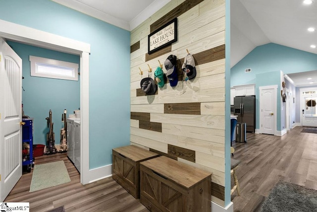 mudroom with washer and clothes dryer, wood-type flooring, vaulted ceiling, and ornamental molding