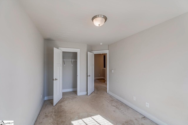 unfurnished bedroom with a closet and light carpet