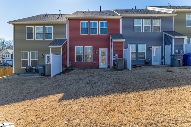 back of house with central AC, a lawn, and a patio