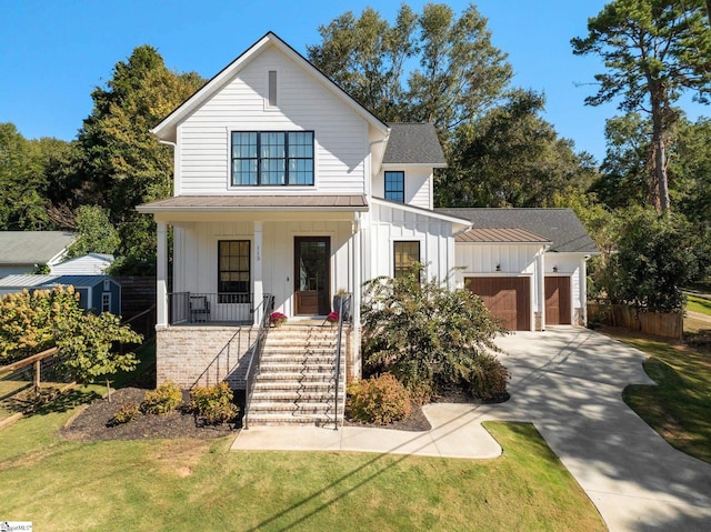 view of front of house featuring a garage, a front lawn, and covered porch