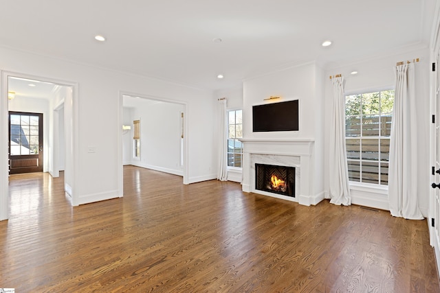 unfurnished living room with dark hardwood / wood-style flooring, ornamental molding, and a fireplace