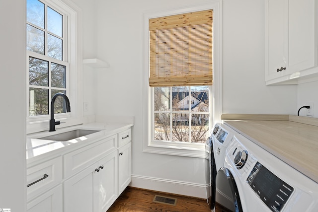 laundry room with separate washer and dryer, a wealth of natural light, cabinets, dark hardwood / wood-style flooring, and sink