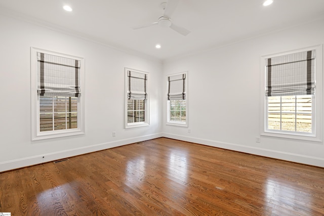 unfurnished room with ceiling fan, a wealth of natural light, crown molding, and hardwood / wood-style floors