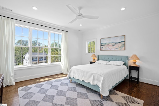 bedroom featuring ceiling fan, ornamental molding, and dark hardwood / wood-style floors