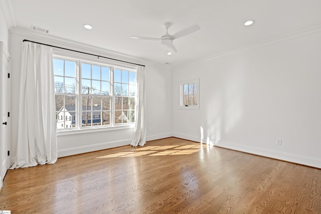 empty room with ceiling fan, crown molding, and light wood-type flooring