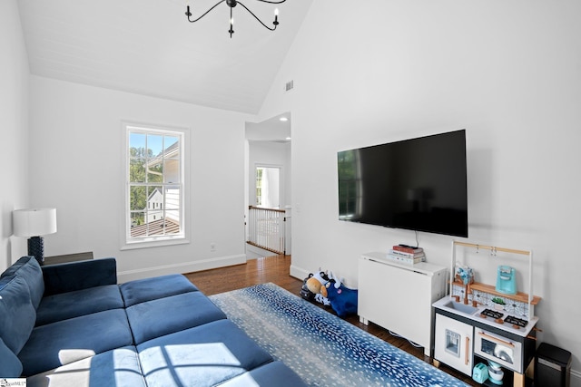 living room with high vaulted ceiling, dark hardwood / wood-style flooring, and a notable chandelier