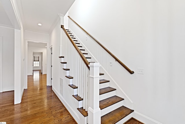 staircase featuring ornamental molding and hardwood / wood-style flooring