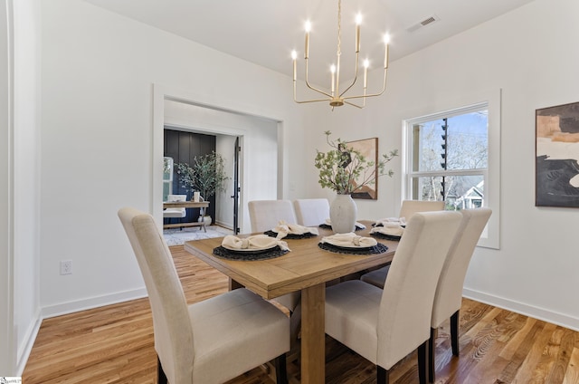 dining space with an inviting chandelier and light hardwood / wood-style floors
