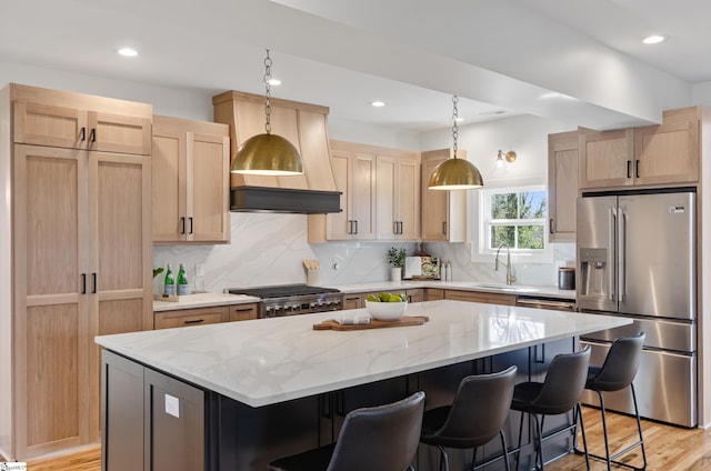 kitchen featuring tasteful backsplash, a kitchen island, sink, appliances with stainless steel finishes, and light brown cabinets