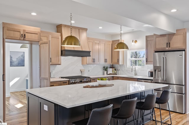 kitchen with appliances with stainless steel finishes, backsplash, a kitchen island, pendant lighting, and sink