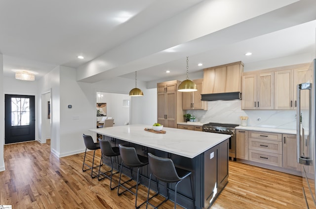 kitchen with light brown cabinetry, custom range hood, high quality appliances, and a kitchen island