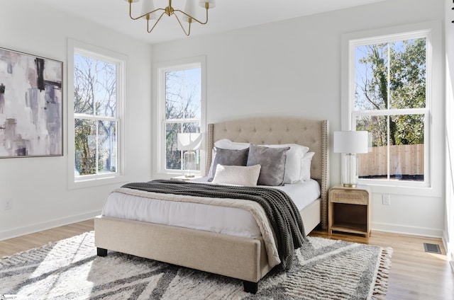 bedroom featuring hardwood / wood-style flooring and an inviting chandelier