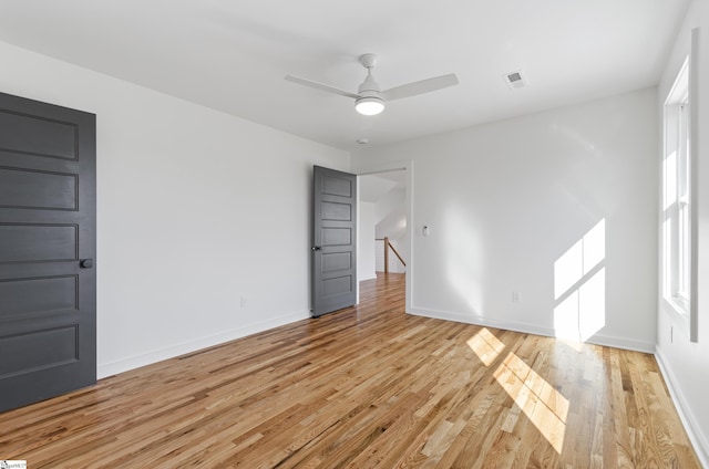 unfurnished room with ceiling fan, light wood-type flooring, and a wealth of natural light