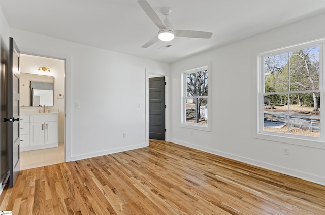 unfurnished bedroom with ceiling fan, ensuite bathroom, and light hardwood / wood-style floors
