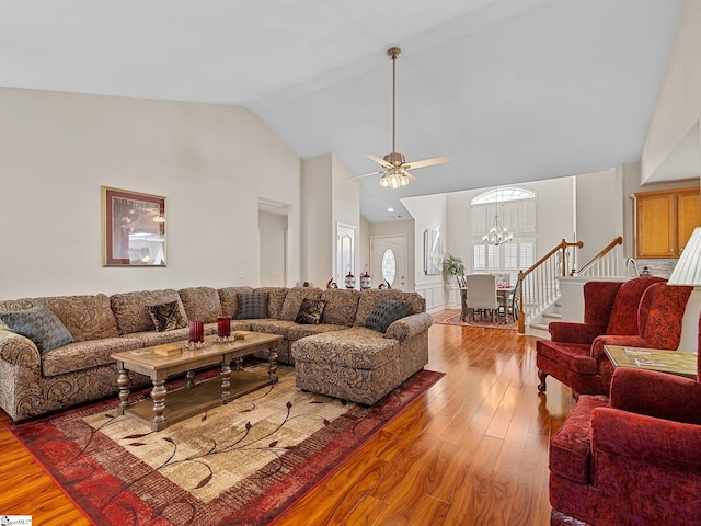 living room with high vaulted ceiling, light hardwood / wood-style flooring, and a notable chandelier