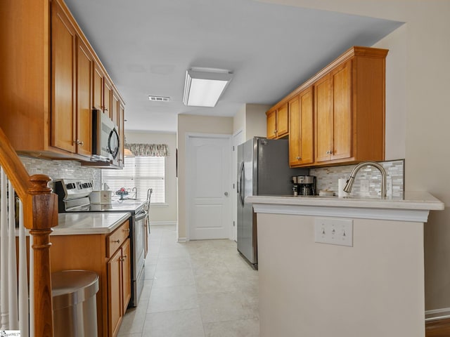 kitchen with stainless steel appliances, backsplash, and sink
