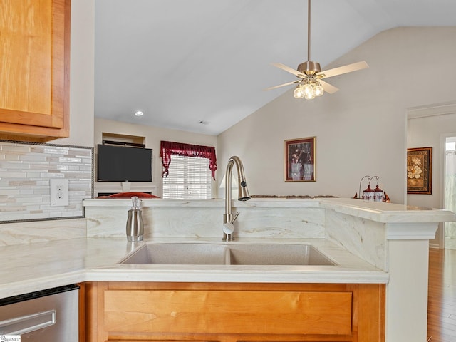 kitchen with ceiling fan, vaulted ceiling, stainless steel dishwasher, decorative backsplash, and sink