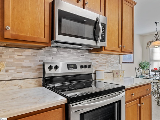 kitchen with decorative light fixtures, backsplash, and stainless steel appliances