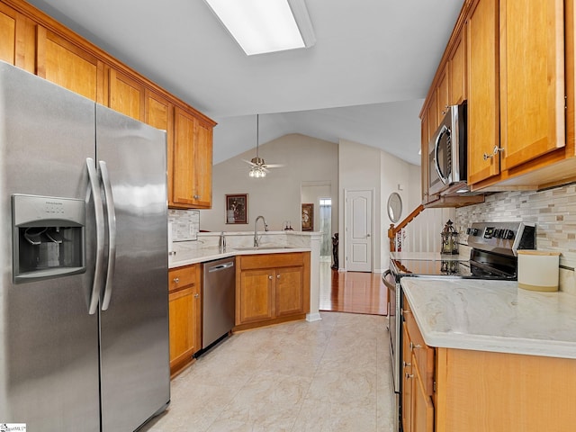 kitchen featuring vaulted ceiling, appliances with stainless steel finishes, tasteful backsplash, and sink
