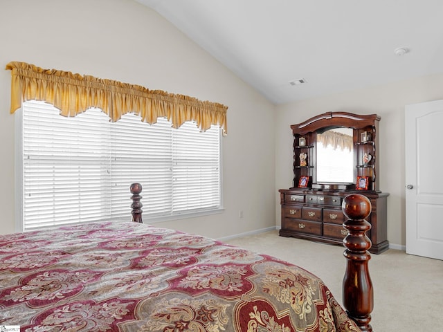 carpeted bedroom featuring lofted ceiling and multiple windows