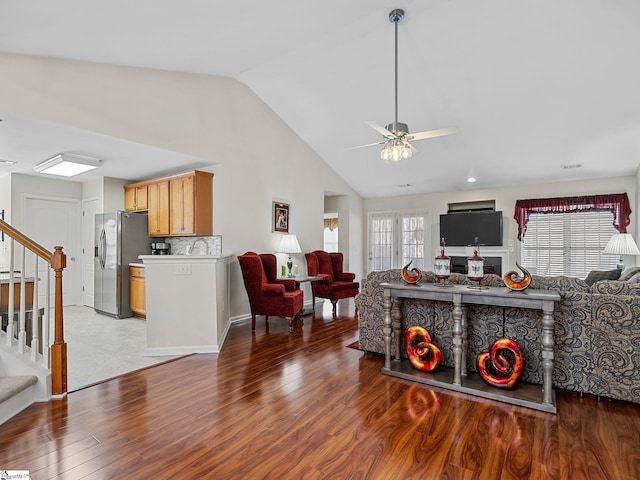 living room with ceiling fan, wood-type flooring, and lofted ceiling