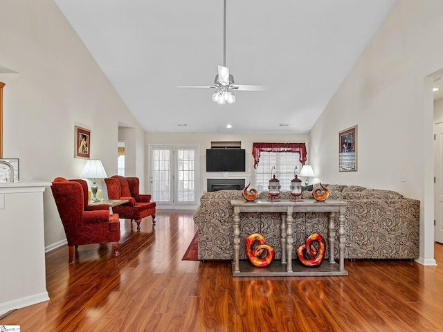 living room featuring ceiling fan, hardwood / wood-style floors, and high vaulted ceiling