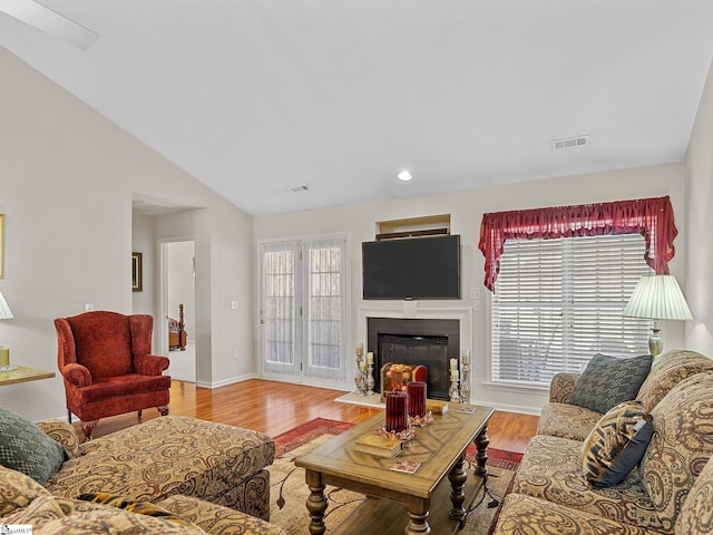 living room featuring lofted ceiling and light wood-type flooring