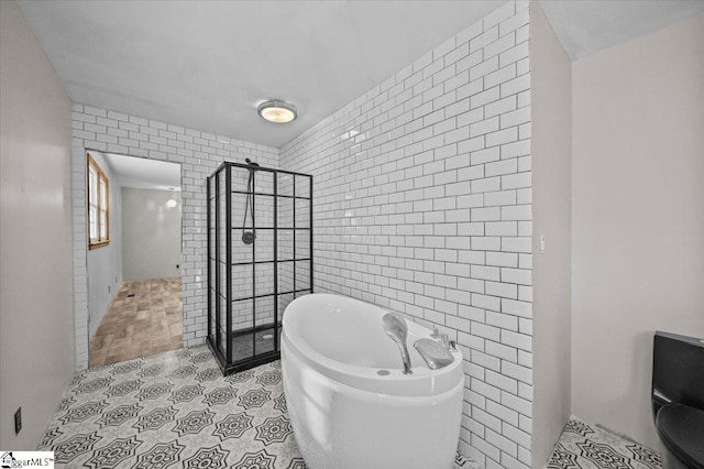 bathroom featuring tile walls and independent shower and bath