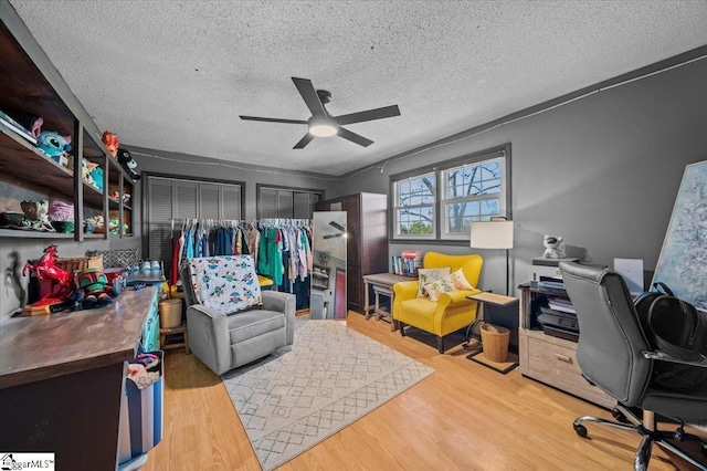 home office featuring a textured ceiling, ceiling fan, and light hardwood / wood-style floors