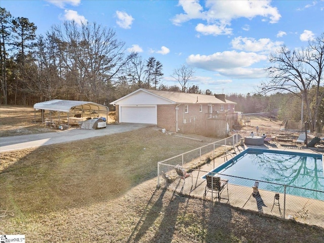 view of swimming pool with a carport, a yard, and a garage