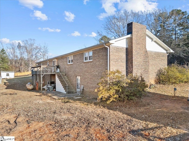 rear view of property featuring a wooden deck