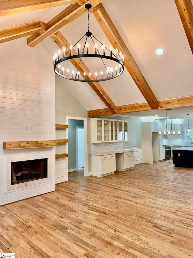 unfurnished living room featuring beamed ceiling, high vaulted ceiling, and light hardwood / wood-style floors