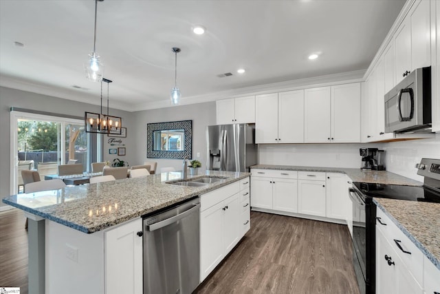 kitchen with white cabinets, appliances with stainless steel finishes, and a center island with sink