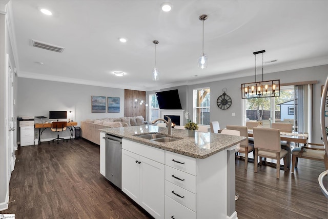 kitchen with sink, decorative light fixtures, white cabinetry, light stone counters, and a center island with sink