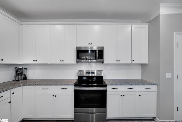 kitchen with crown molding, appliances with stainless steel finishes, backsplash, white cabinets, and dark stone counters