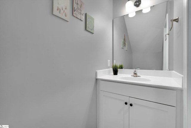 bathroom with vanity and lofted ceiling