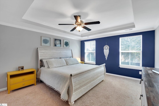 carpeted bedroom featuring ceiling fan, a tray ceiling, and crown molding